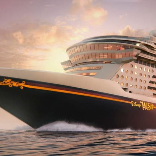 Kreuzfahrtschiff mit modernem Design, fährt durch ruhige Gewässer bei Sonnenuntergang.