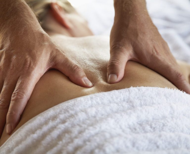 Eine Person erhält eine Rückenmassage mit entspannenden Handbewegungen.