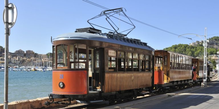 Alter Straßenbahnwagen an der Küste, mit Meerblick und einem klaren blauen Himmel.
