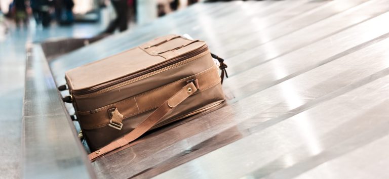 Braune Tasche auf einem Gepäckband in einem Flughafen.